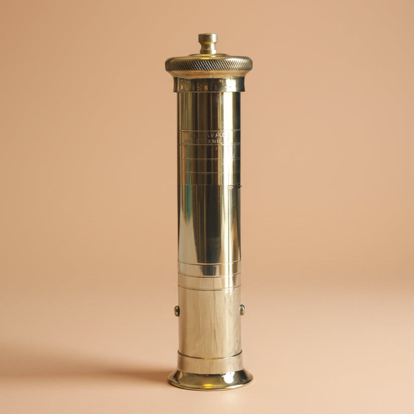 Brass and silver cylindrical object on a white background