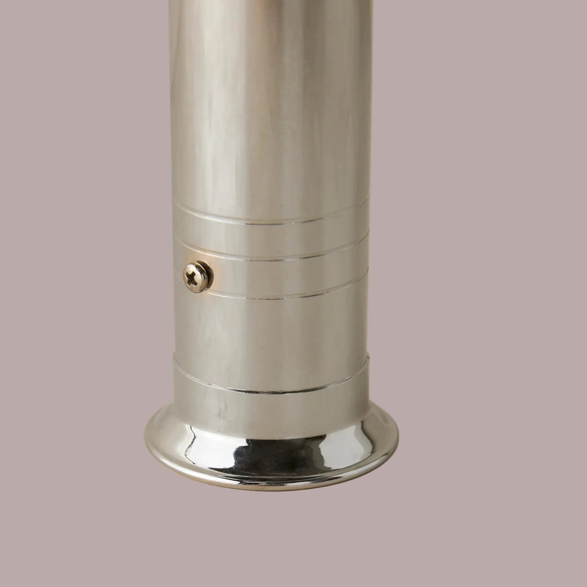 Metallic cylindrical object on a beige background