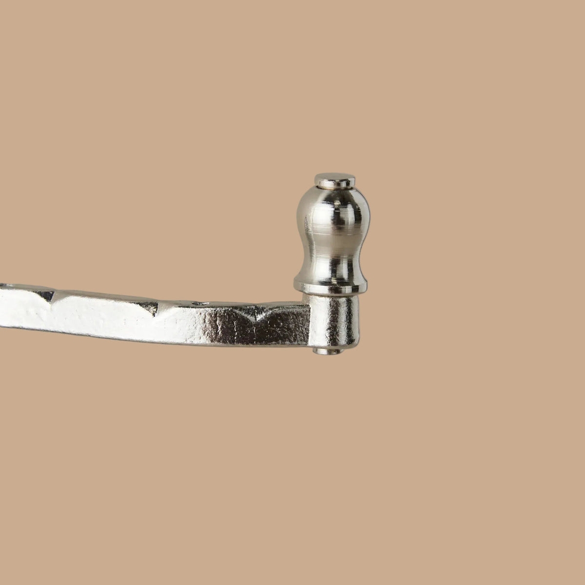 Metallic tool with a handle on a beige background