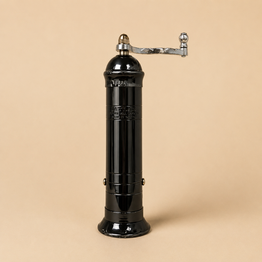 Atlas Black Pepper Mill handmade in Greece featuring a glossy black metal body, polished chrome handle, and beige studio background. Traditional manual pepper grinder with durable metal grinding mechanism.
