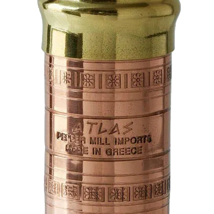 Copper pepper mill with gold top on a light gray background