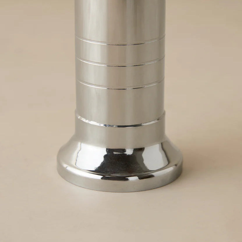 Close-up of a metallic cylindrical object on a beige background