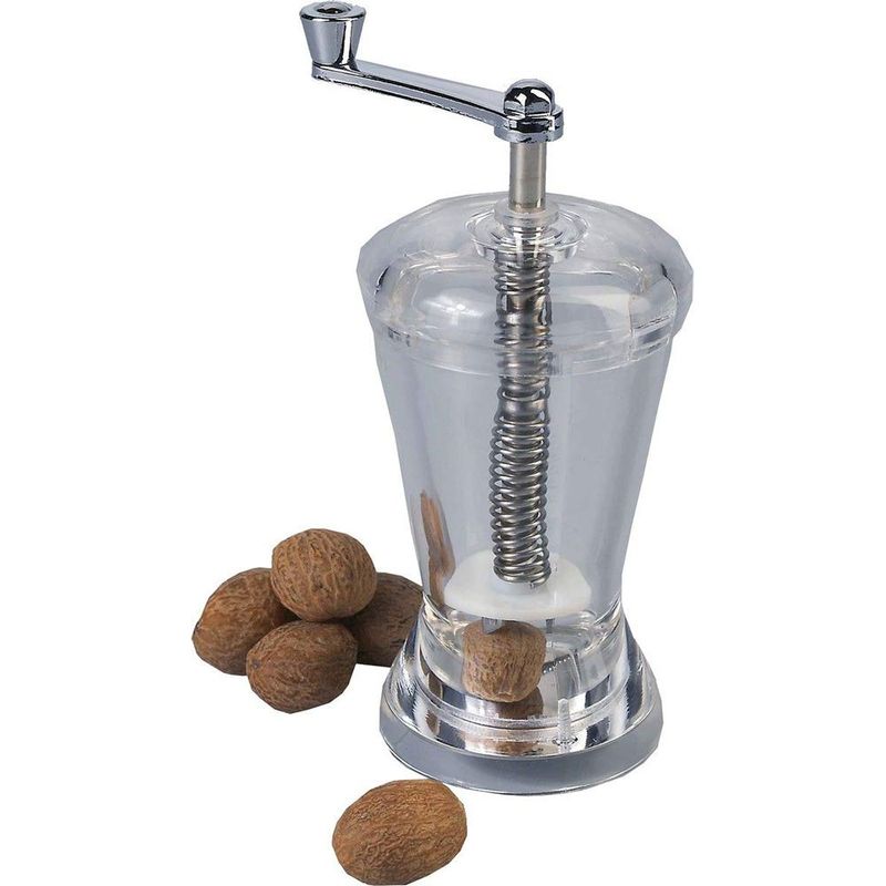 Clear pepper grinder with metal handle and springs, accompanied by whole nuts on a white background