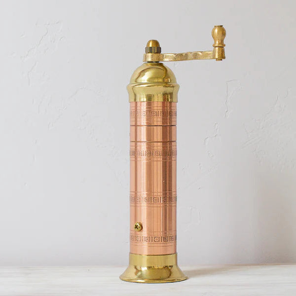 Brass pepper grinder on a white background