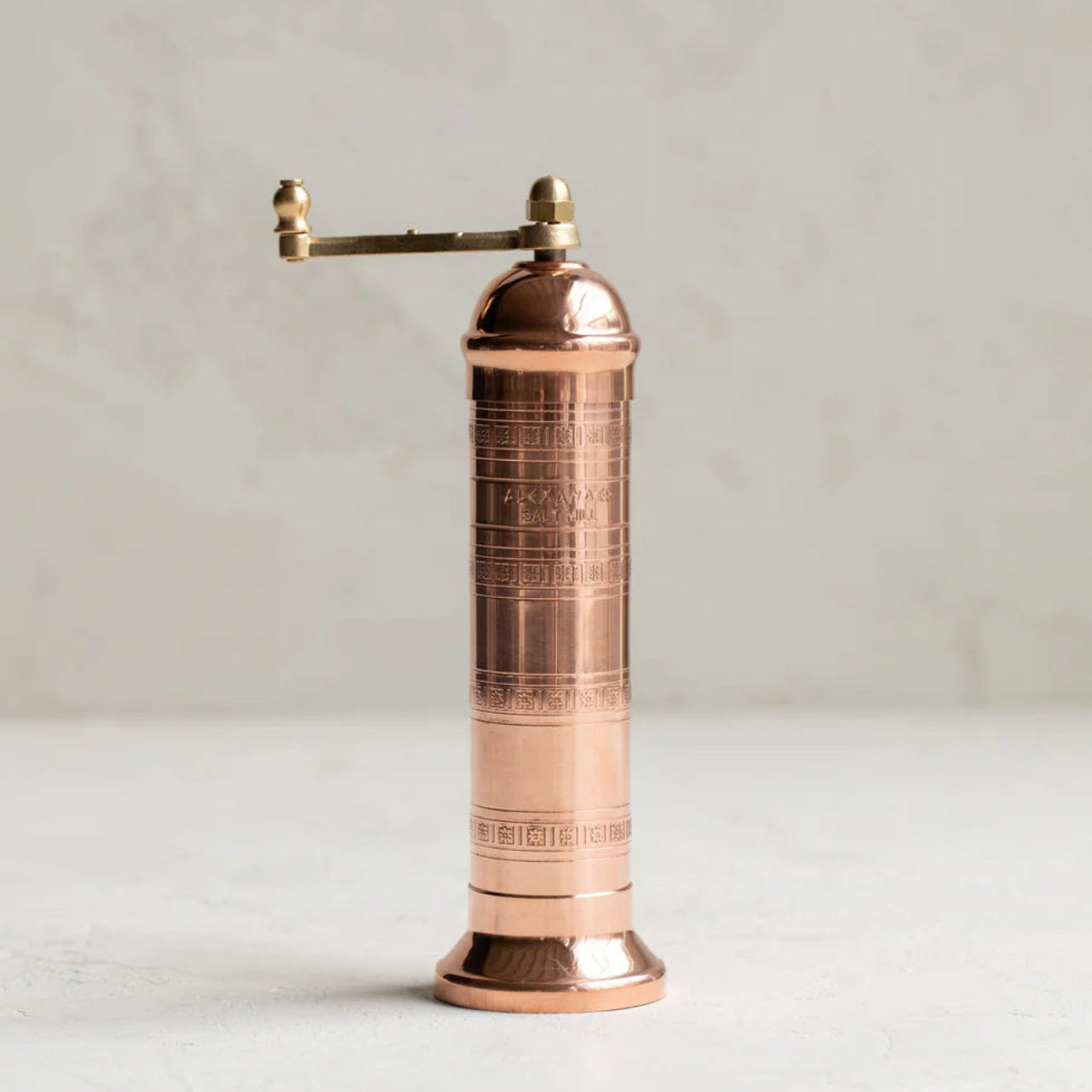 Copper pepper grinder on a light background