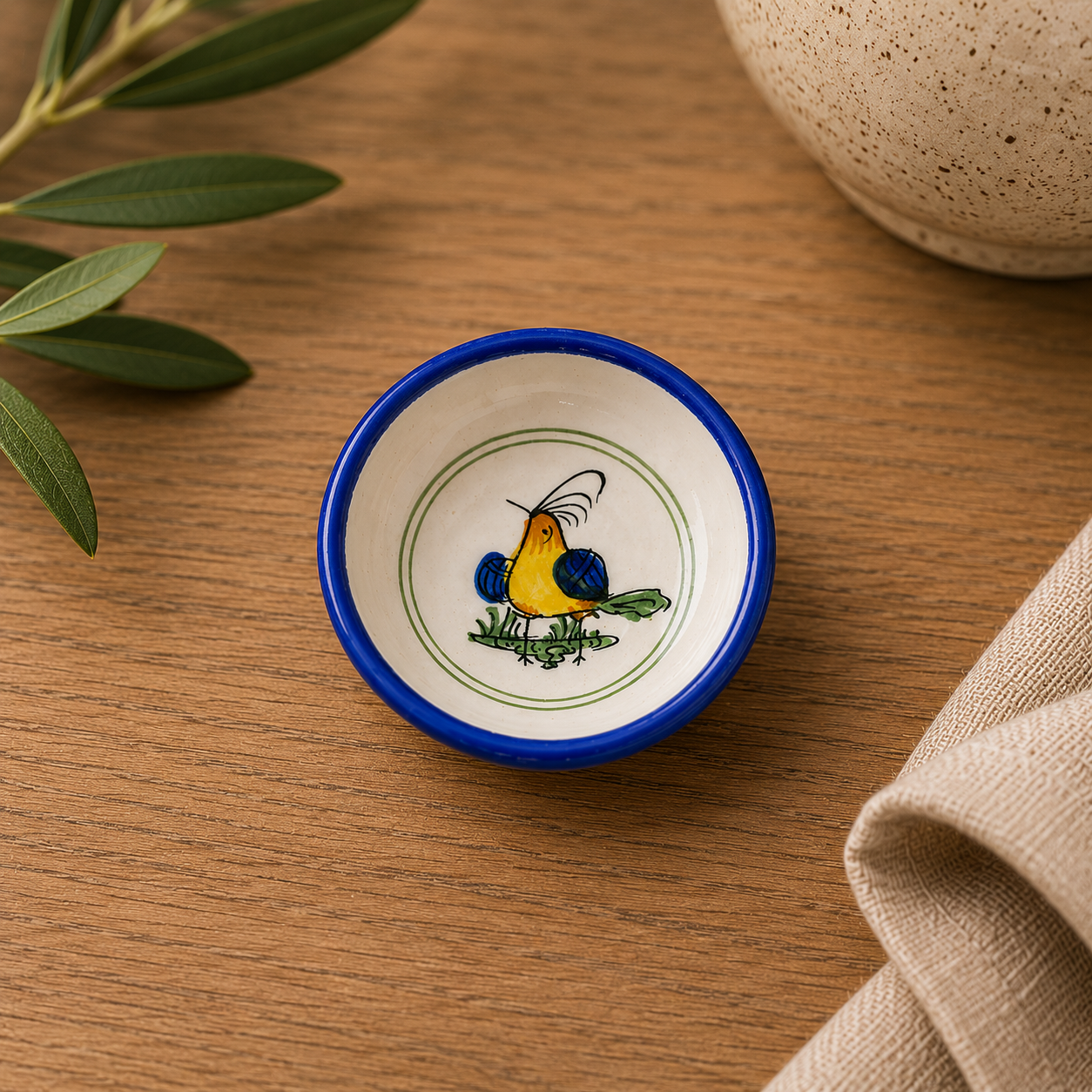 Small ceramic dish with a bird design on a wooden surface