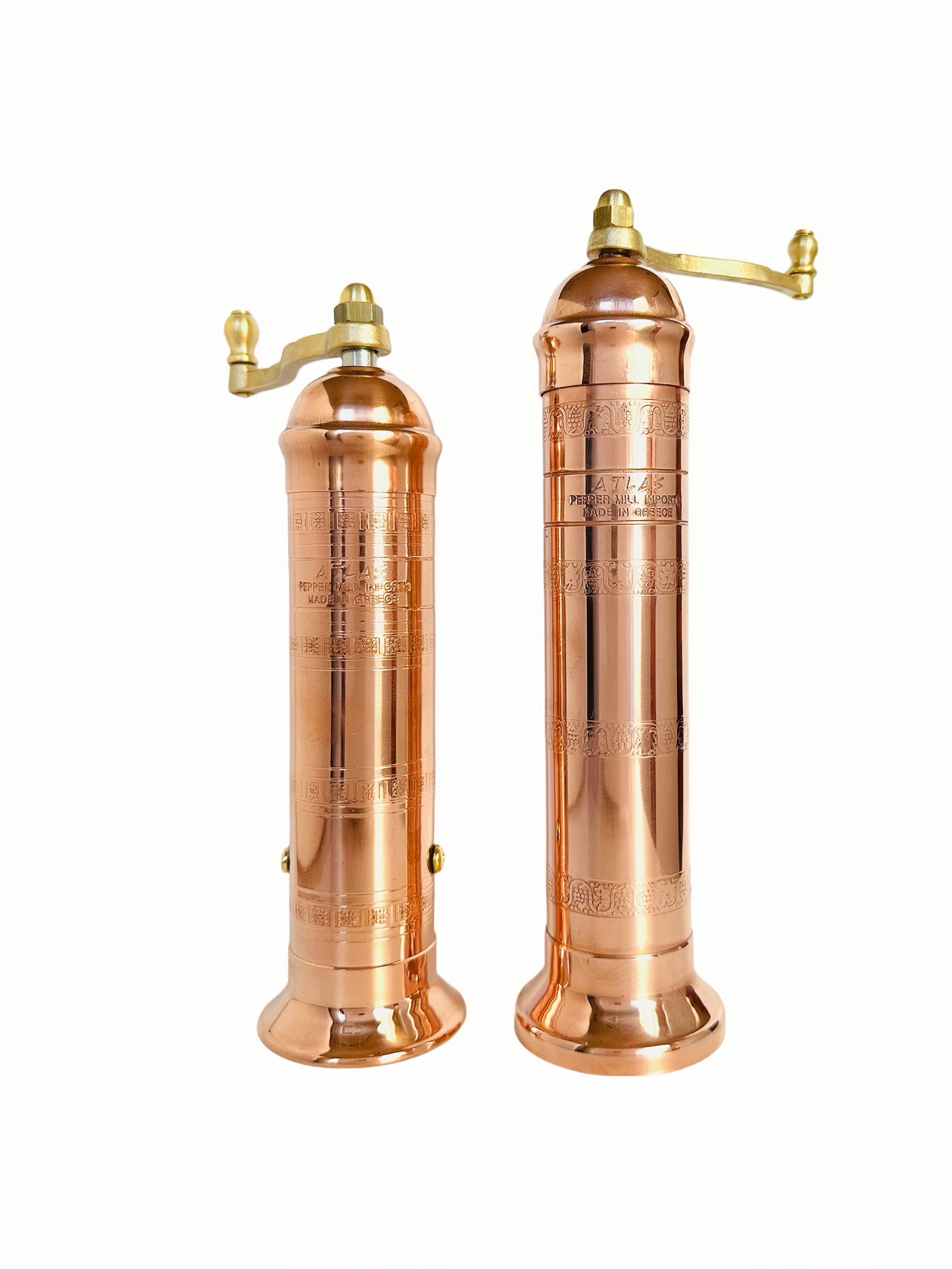 Two copper pepper mills on a white background