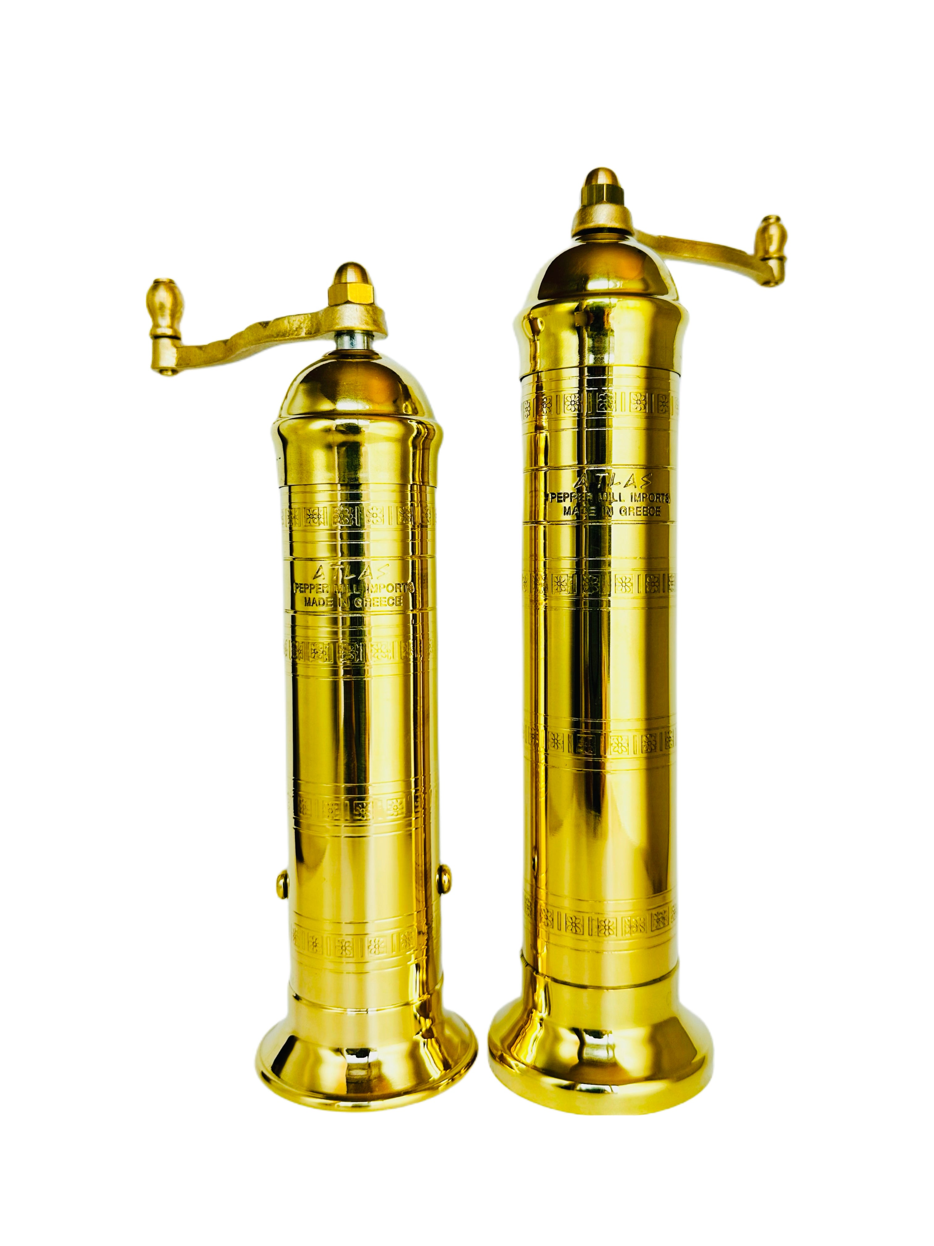 Two brass pepper mills on a white background