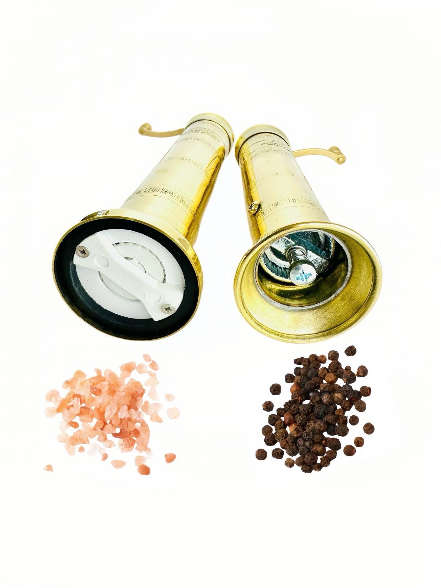 Two brass pepper mills with salt and pepper on a white background